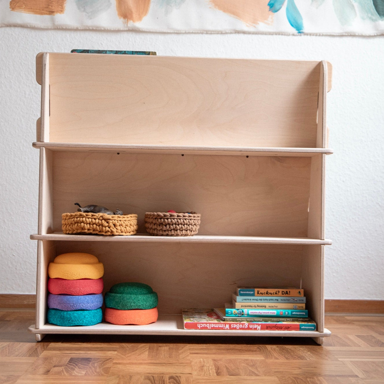 Rückseite Montessori Bücherregal mit Spielsachen in den Regalfächern